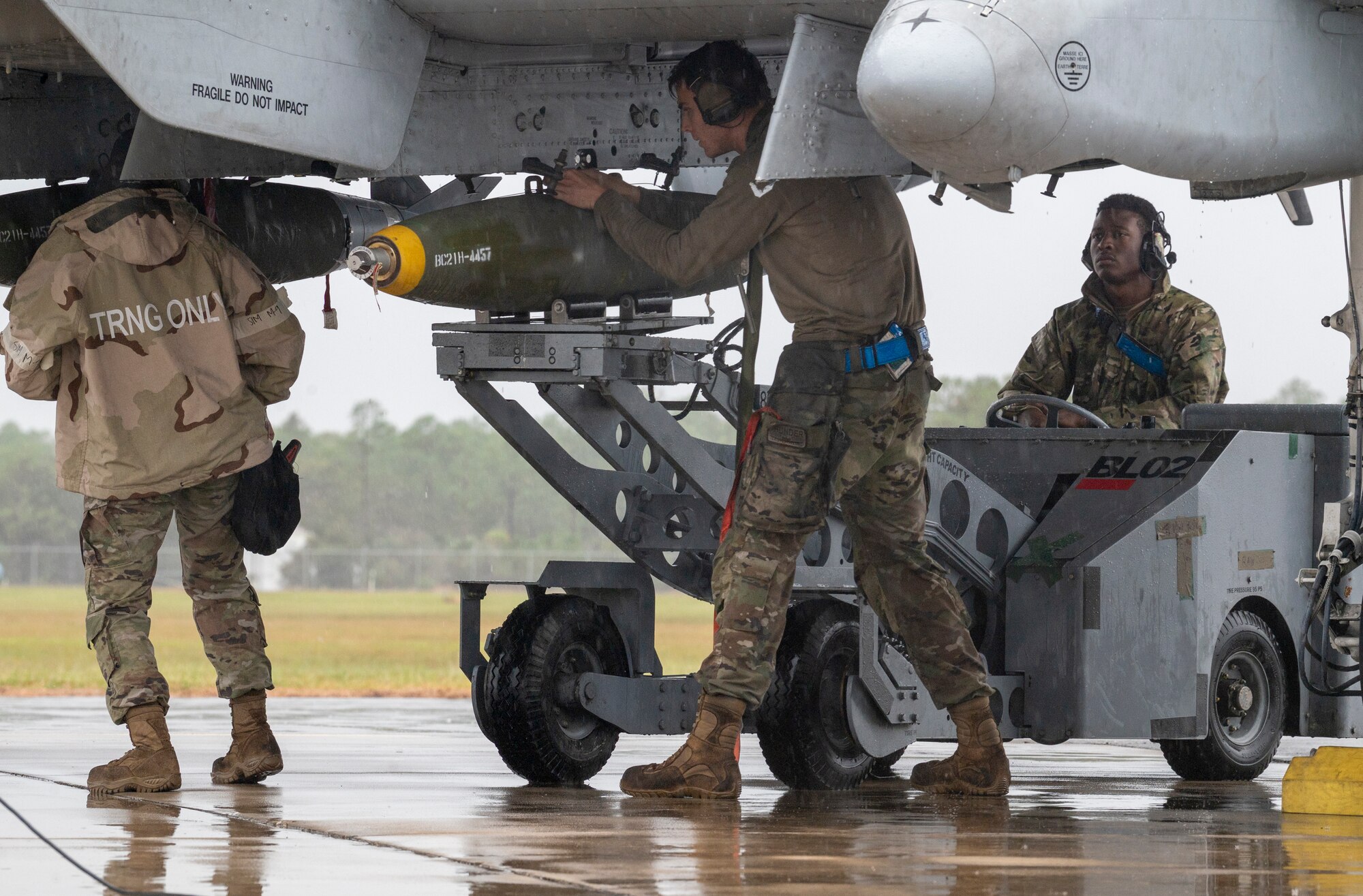 U.S. Air Force Airman 1st Class Kaylee Jordan (left), 74th Fighter Generation Squadron weapons load crewmember, U.S. Air Force Staff Sgt. David Walker (center), 74th FGS weapons load team chief, and U.S. Air Force Senior Airman Howell Marian (right), 74th FGS weapons load crewmember, prepare to download munitions during an integrated combat turn at Avon Park Air Force Range, Florida, Nov. 15, 2023. ICTs enable the quick rearming and refueling of a running aircraft to reduce the aircrew’s ground time to quickly get them back in the air. (U.S. Air Force photo by Airman 1st Class Leonid Soubbotine)