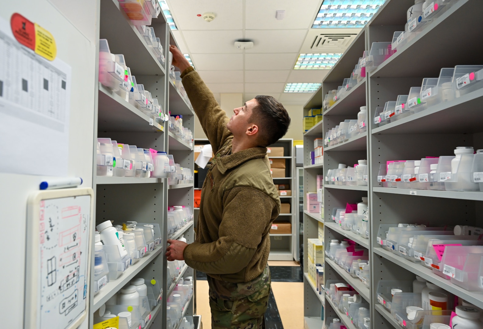 U.S. Air Force Senior Airman Connor Colassaco, 52nd Medical Group pharmacy vault custodian, reaches for medication at Spangdahlem Air Base, Germany, Dec. 14, 2022. Members of the pharmacy count and label all controlled medication to ensure it is properly inventoried. (U.S. Air Force photo by Senior Airman Jessica Sanchez-Chen)