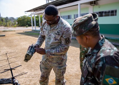 U.S. Army Staff Sgt. David Dixon, assigned to the 56th Signal Battalion, Army South, trains Brazilian soldiers on the 117-G TACSAT radio at Southern Vanguard 24 in Macapa, Brazil, Nov. 10, 2023. Southern Vanguard 24 is an annual bilateral exercise designed to enhance partner interoperability between participating U.S., and Brazil. (U.S. Army National Guard photo by Staff Sgt. Jonathan Pietrantoni)