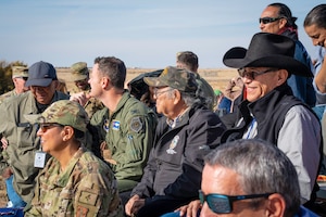 Crowd of people watch a combat search and rescue demonstration.