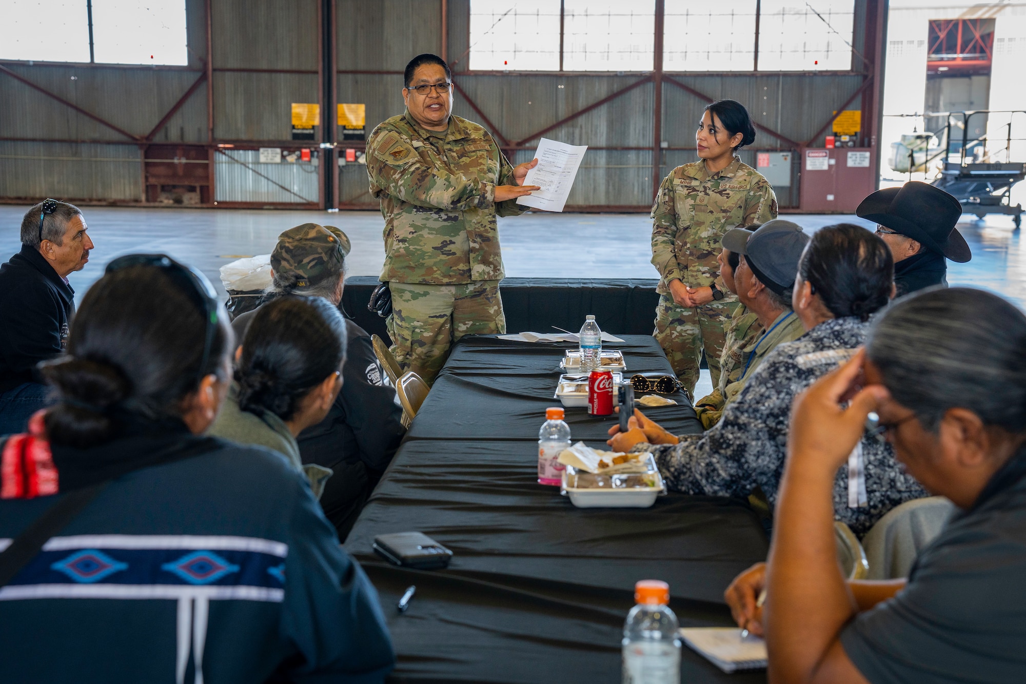 Man and woman conduct a briefing for a crowd of people.