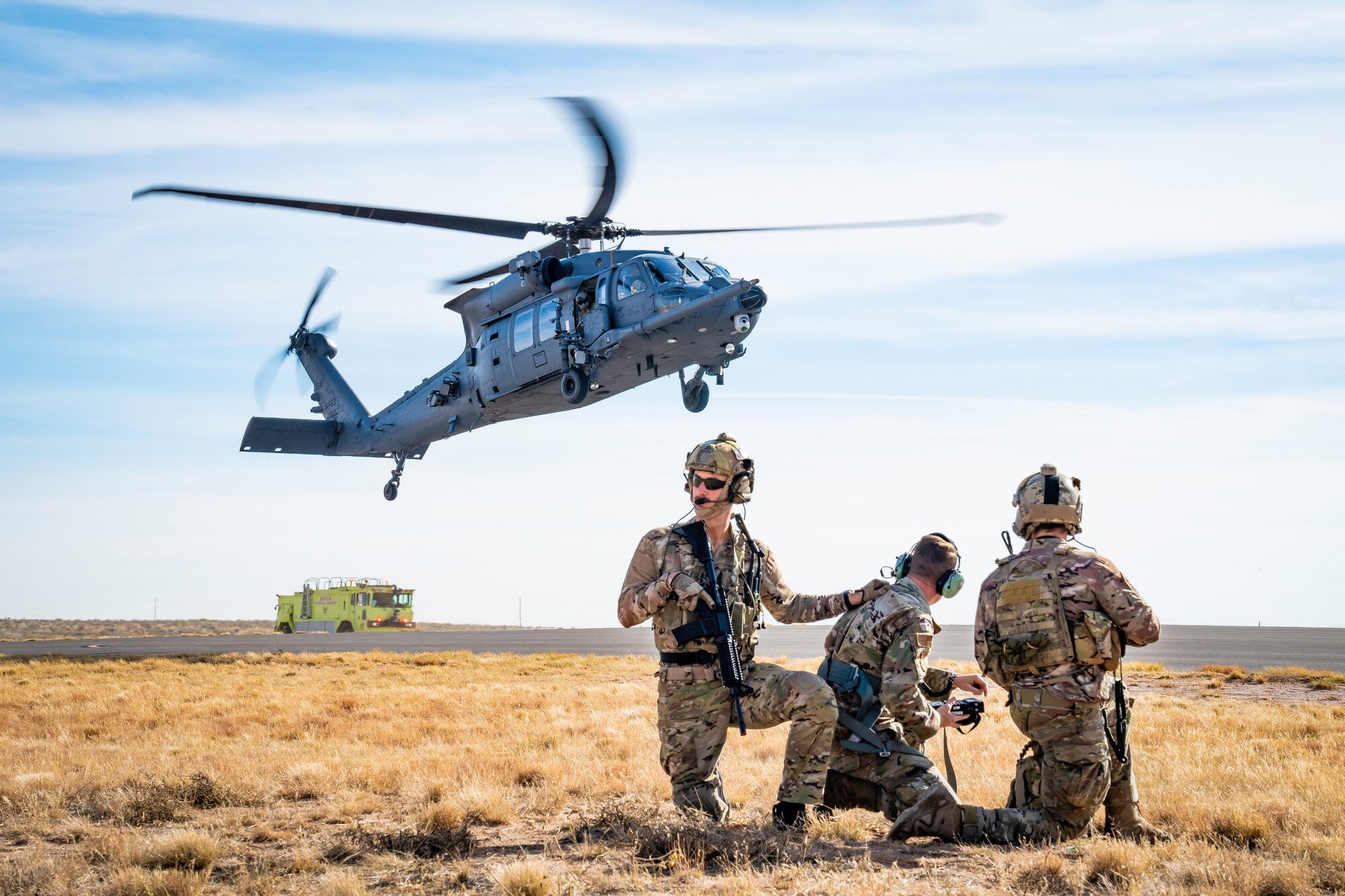 Helicopter landing in front of a group of people.