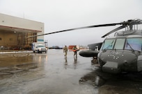 Alaska Army National Guard Chief Warrant Officer 2 David Berg, left, with Golf Company, 2-211th (General Support Aviation Battalion) and Chief Warrant Officer 3 Nick Lime, an aviation maintenance technician and crew chief with Delta Co., 2-211th (GSAB), load medical equipment to a UH-60L Black Hawk helicopter before departing Bethel, Alaska, en route to Napaskiak during a medevac mission Nov. 15, 2023.