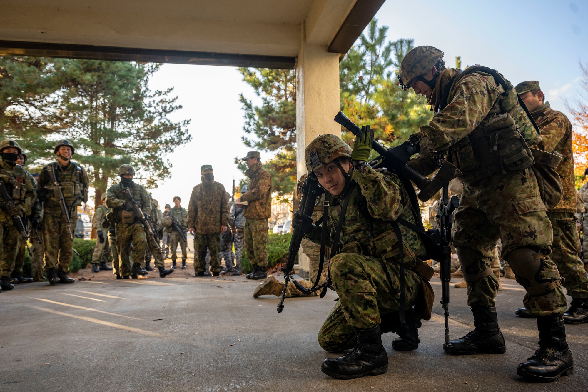 Japanese service member preparing to breach a door.