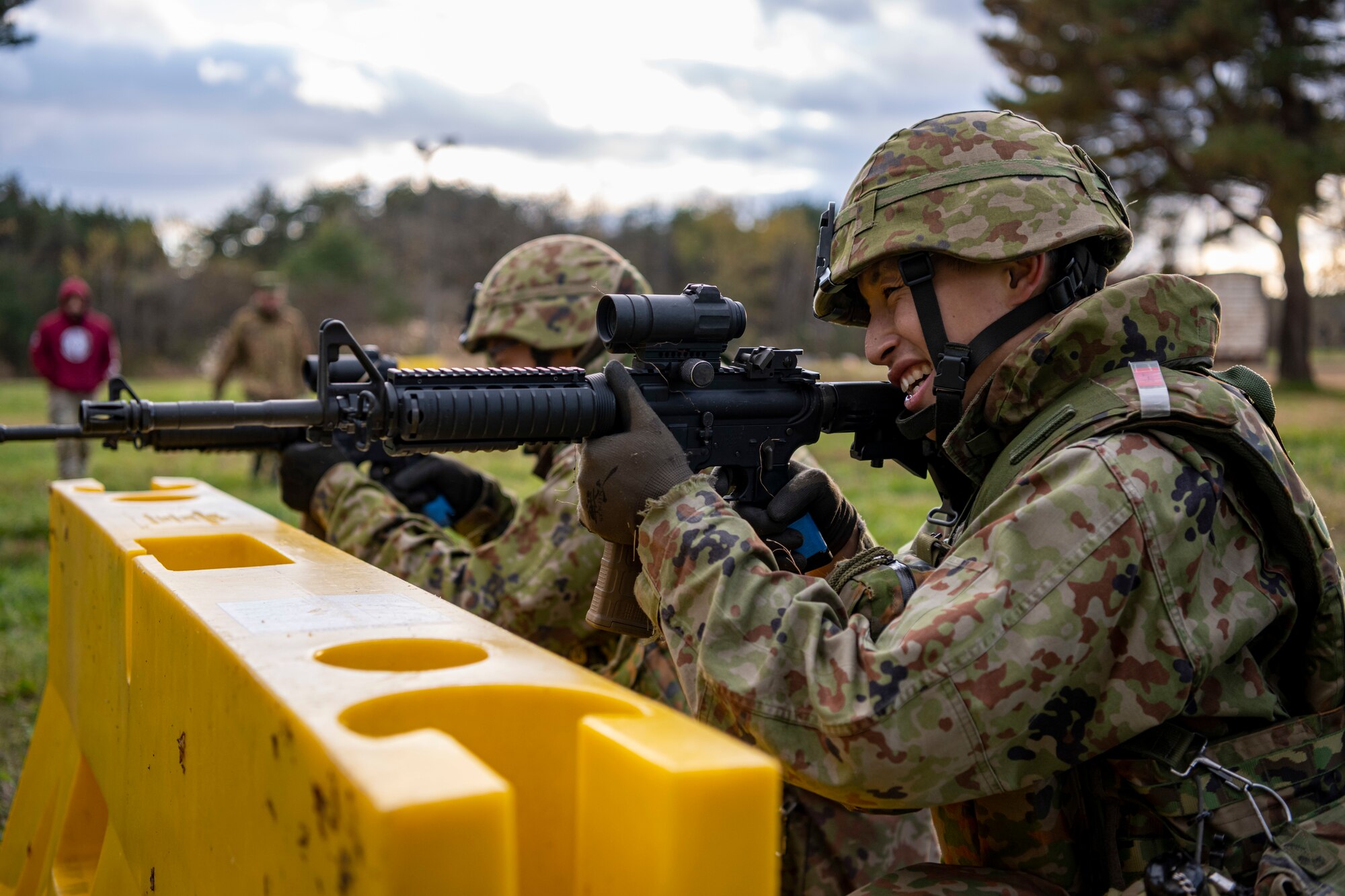 Japanese service member aim down the site.