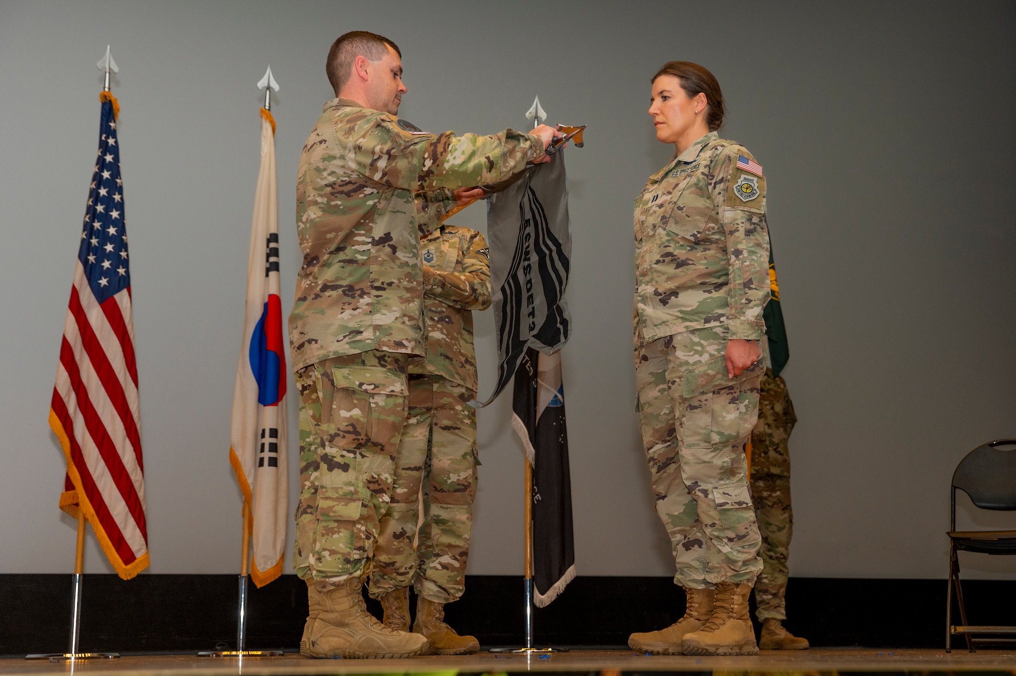 U.S. Space Force Lt. Col. Micheal Provencher, 5th Space Warning Squadron commander, and Capt. April Dybal, 5th Space Warning Squadron Detachment 3 commander, reveal the new 5th SWS/Det 3 guidon during the unit’s activation ceremony at Osan Air Base, Republic of Korea, Oct. 27, 2023.