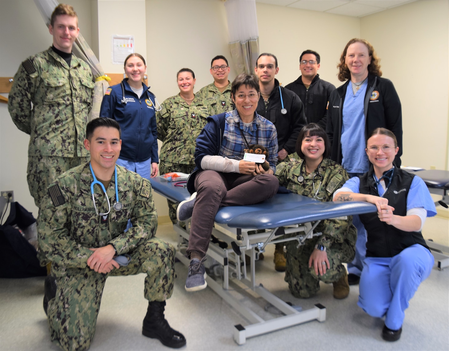 Caring for one of their own…Naval Hospital Bremerton Pediatrics department staff flank Dr. Victoria Crescenzi after providing her mock patient care while she posed as a simulated injured casualty during a mass casualty drill designed to test response efforts, held Nov. 14, 2023. (official Navy photo by Douglas H Stutz, NHB/NMRTC Bremerton public affairs officer).