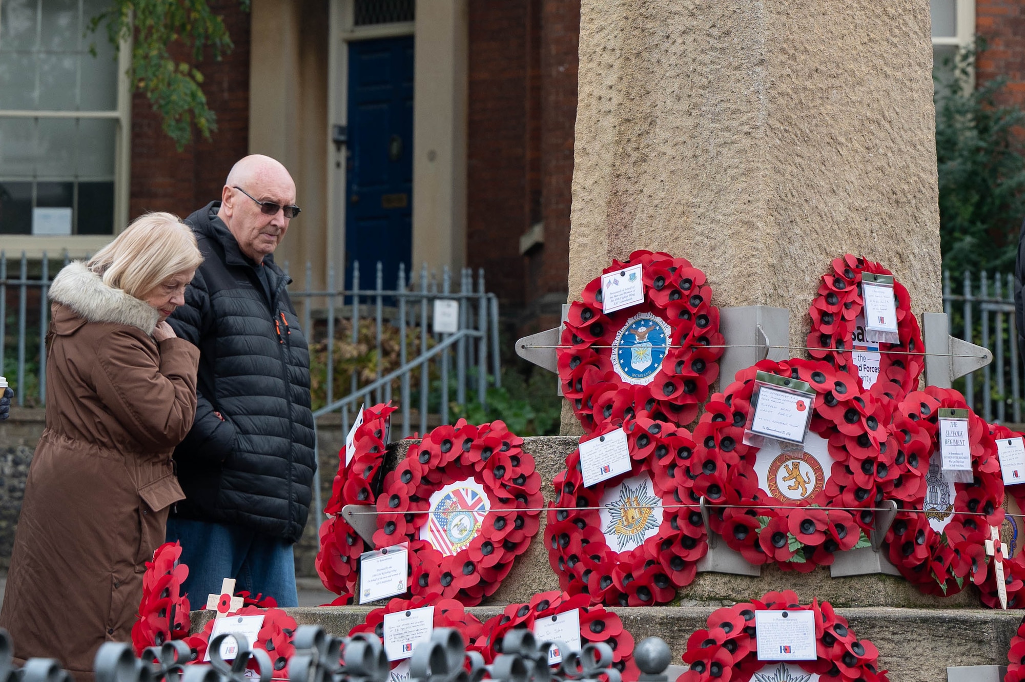 2 people look at poppy wreaths set up for Remembrance Day