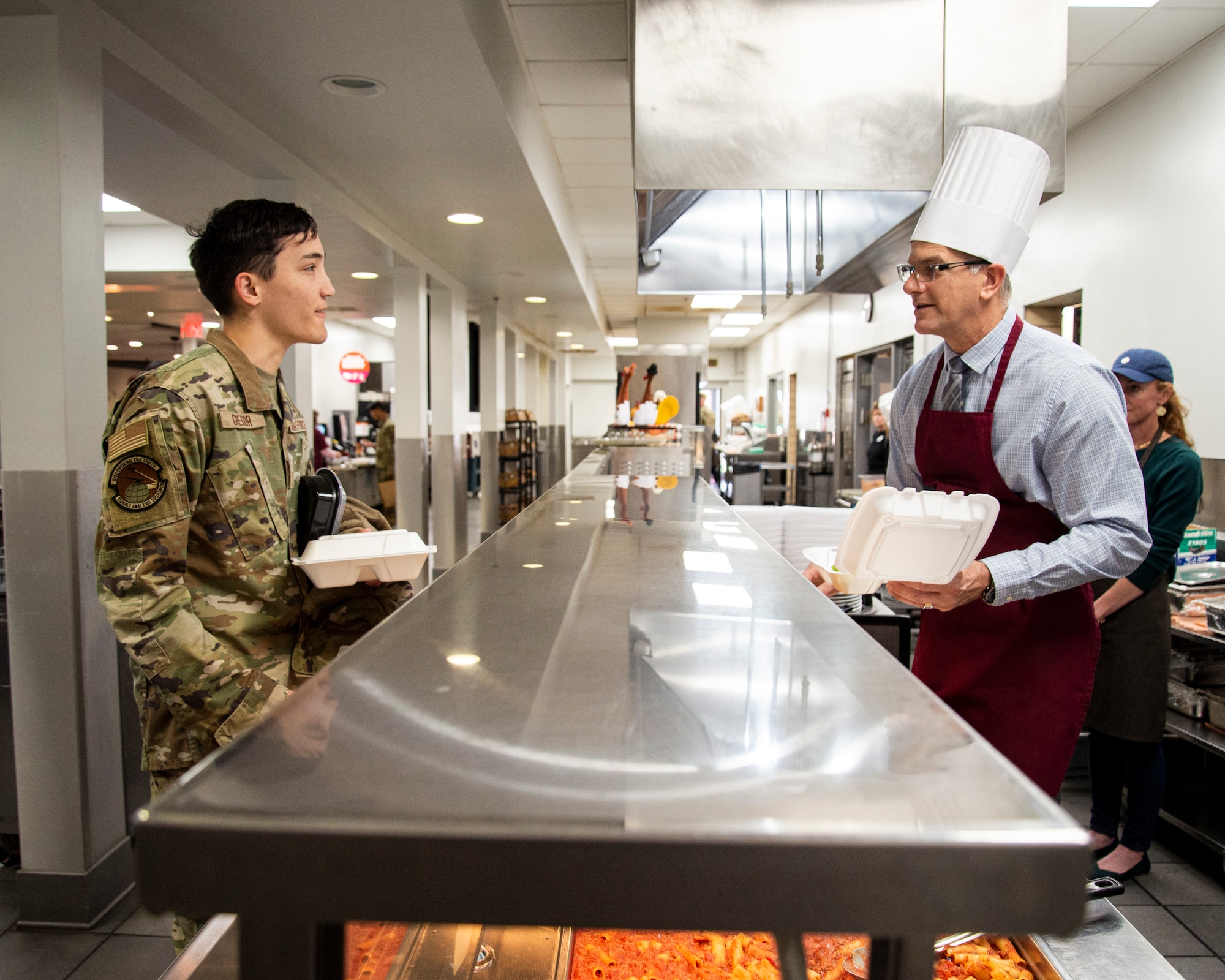 Man serves food in cafeteria