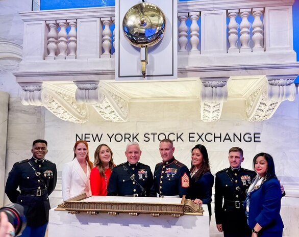 Brig. Gen. David C. Walsh, Sgt. Maj. Allen B. Goodyear, and the MCSC team pose on stage at the New York Stock Exchange moments after the commander rang the closing bell in honor of Veteran's Day and the continued partnership between the Marine Corps and the American business community.