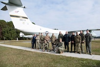 U.S. Air Force and Navy service members pose for a photo with Ukrainian defenders in front of a static aircraft