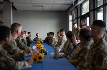 U.S. and Ukrainian military members sit at a table with flowers on it