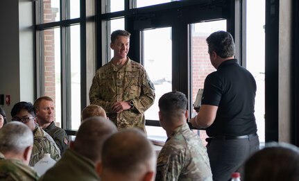 U.S. Air Force Col. Samuel Todd, 437th Airlift Wing commander, receives a gift from Mykola Sarazhynskyy, Protez Foundation events director in a room full of people