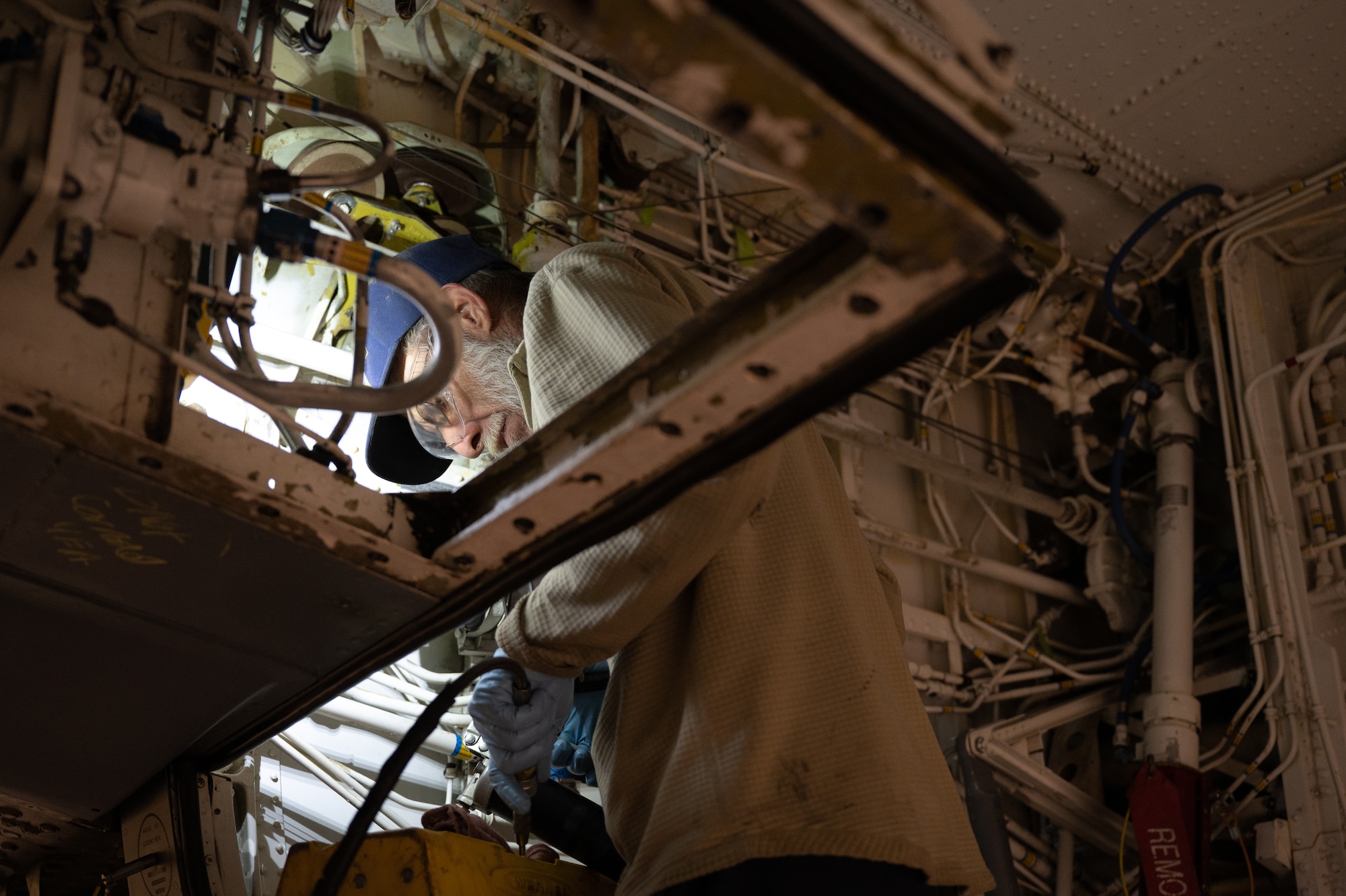 Gerald Smith, 434th Maintenance Squadron civilian aircraft maintenance technician, lubricates a pin under the wing of a KC-135R Stratotanker during its periodic inspection at Grissom Air Reserve Base, Ind., Nov. 8, 2023.