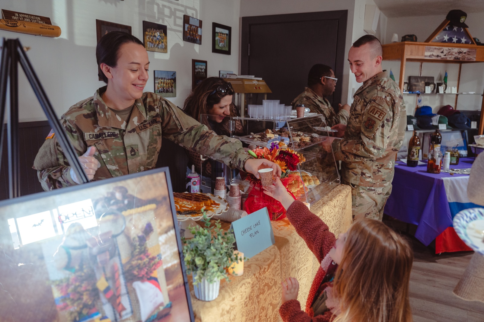 Photo of Service members and civilians serving food and drinks from around the world during a multicultural event at the Vermont National Guard Base, South Burlington, Vermont.