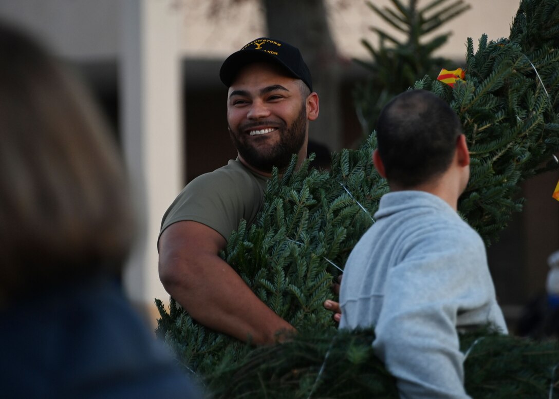 U.S. Air Force Senior Airman Darrion Smith, 316th Comptroller Squadron financial operations technician, carries a donated Christmas tree during the Capitol Christmas Tree event at Joint Base Andrews, Md., Nov. 16, 2023. During the event, military families had the opportunity to receive first come, first served donated Christmas trees in celebration of the holiday season. (U.S. Air Force photo by Senior Airman Austin Pate)