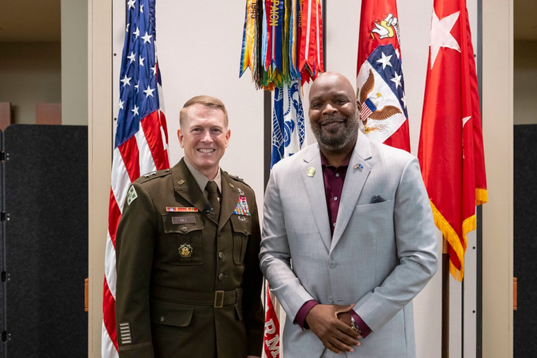 One military man next to a civilian man.