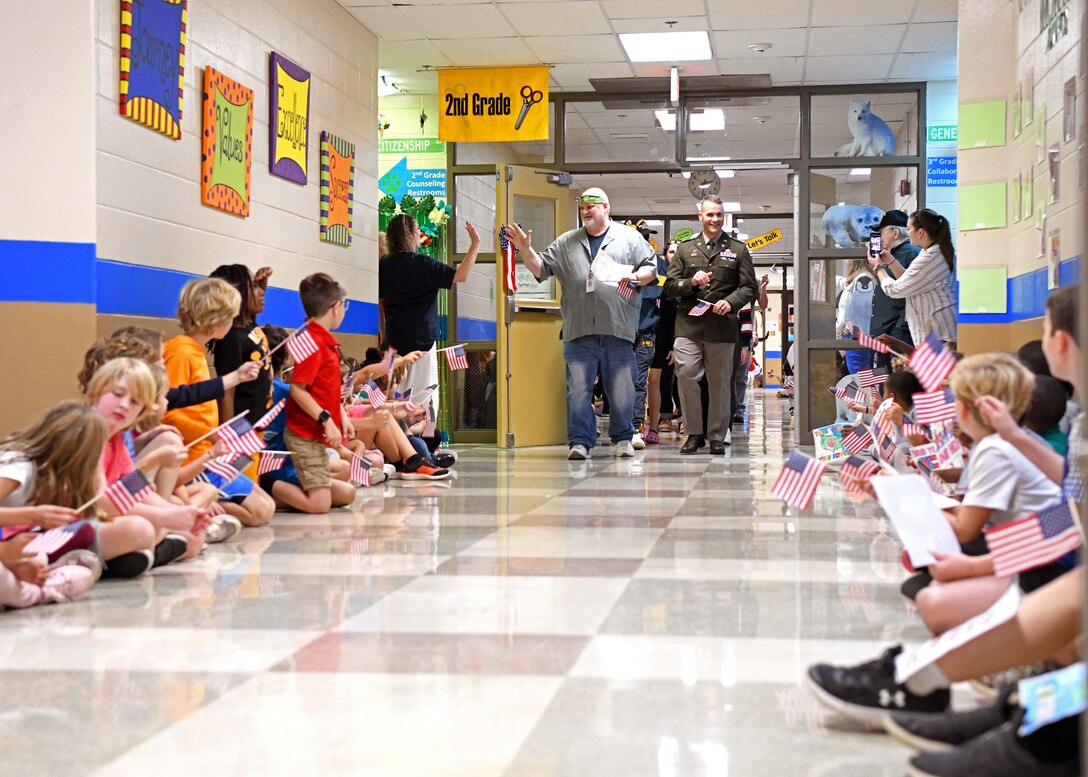 Soldier leading a parade through school.