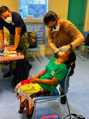 U.S. Navy Lt. Hye Hyun Choi, dentist, performs a dental exam on a young Ebeye elementary student while her assistant, PO3 Roberto Loza records Choi’s findings. The dentists saw about 800 residents over the two-day event on Ebeye.