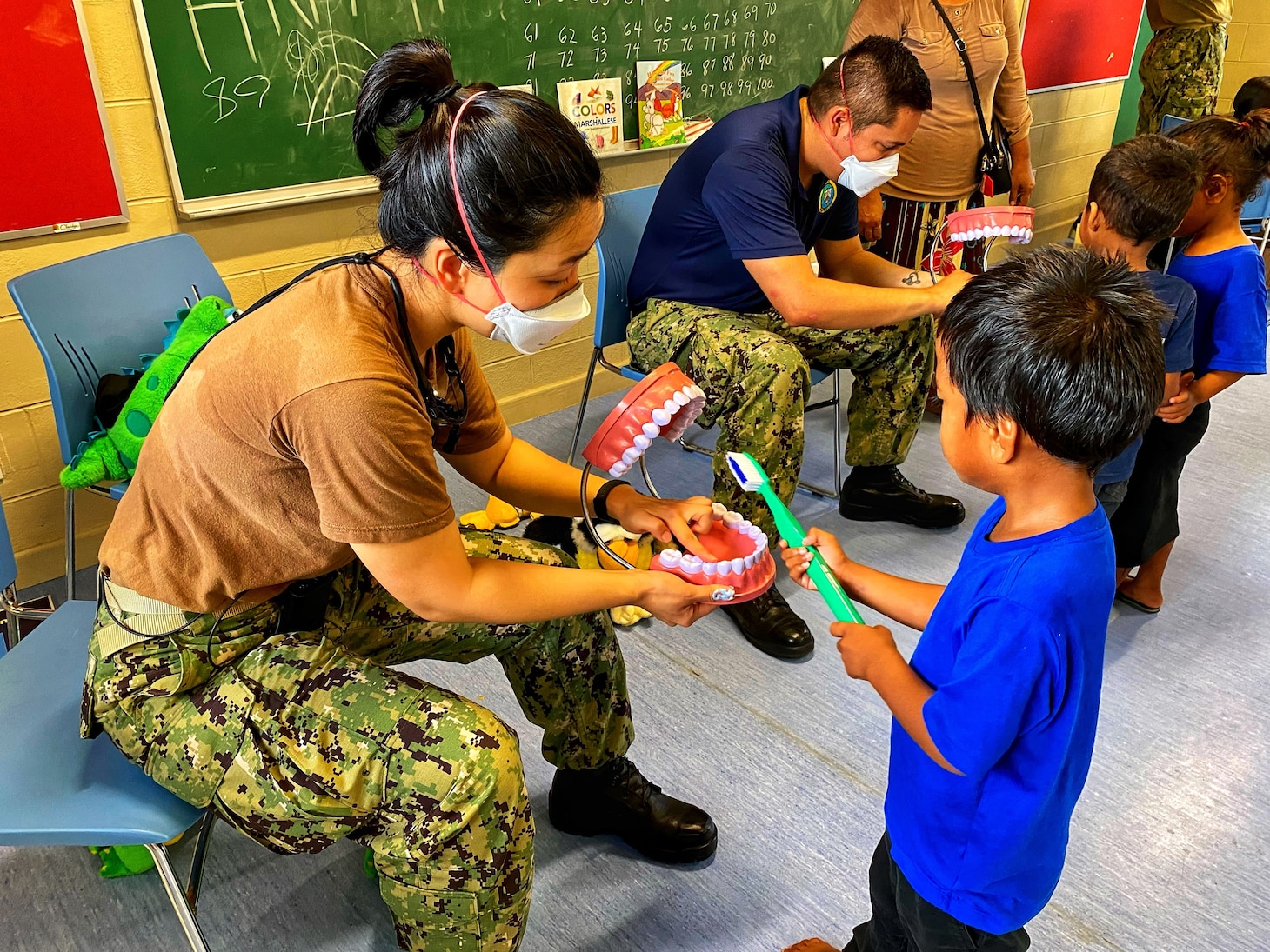 U.S. Navy Lt. Hye Hyun Choi, dentist, shows a young Ebeye student the proper way to brush his teeth. “Don’t forget to brush the back of your teeth!”