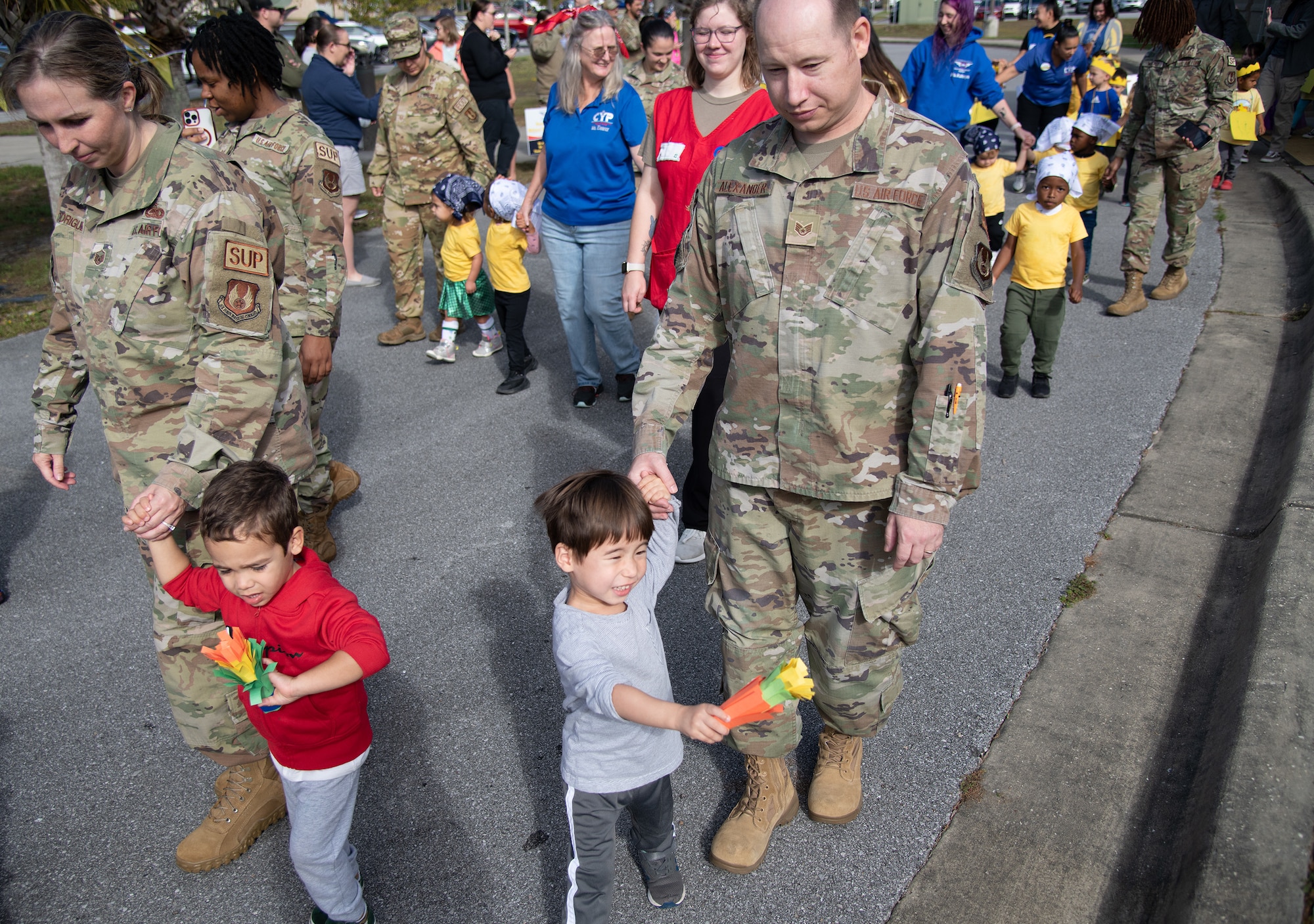 Toddlers and family members walk by during a Child Development Center parade.
