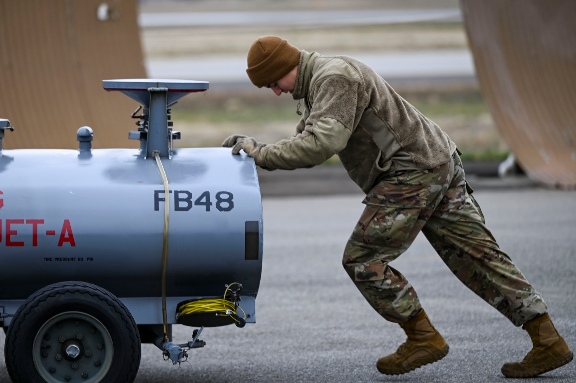 Airmen pushes a cart of fuel