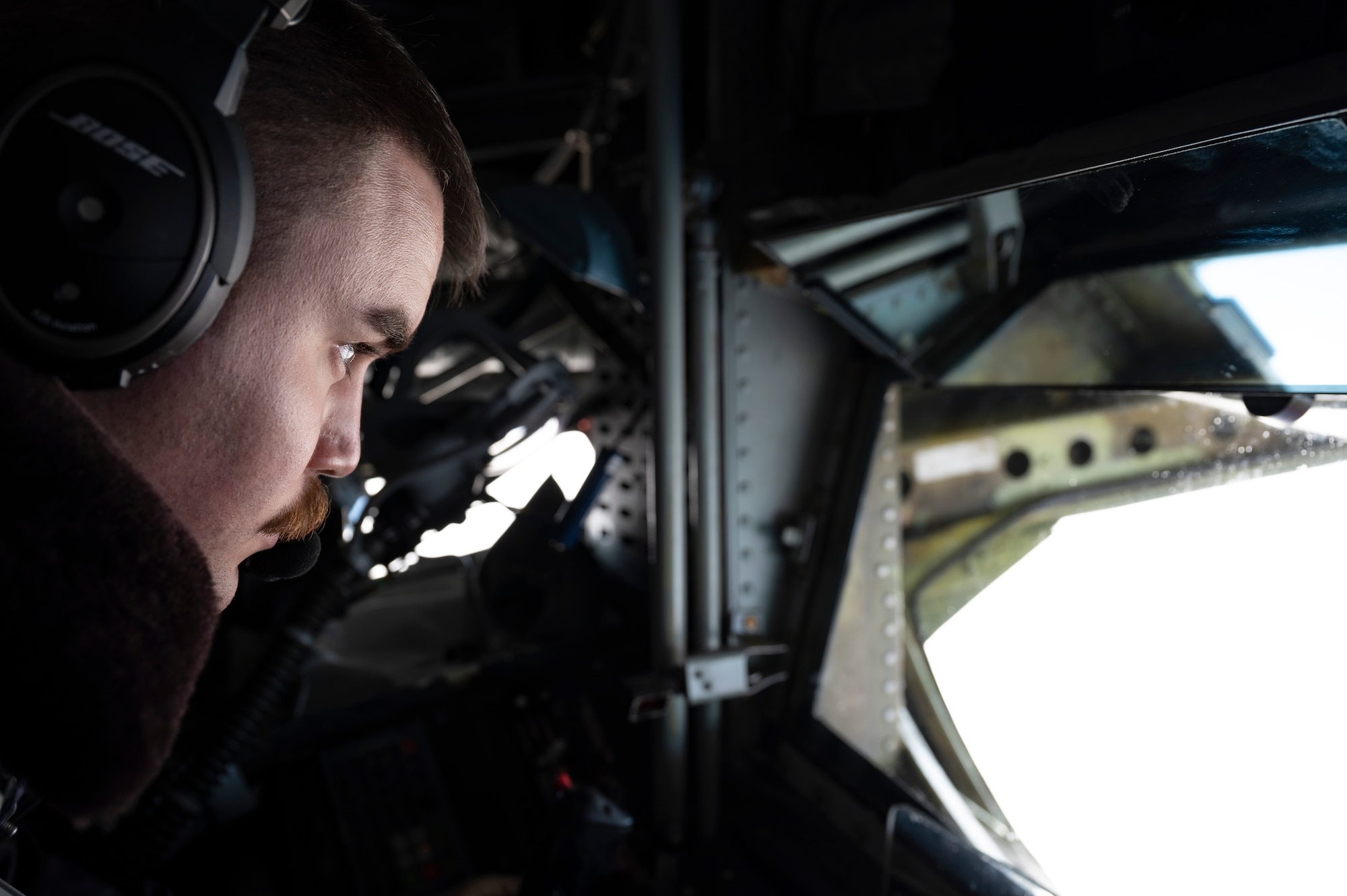An in-flight refueling operator looks out the boom pod