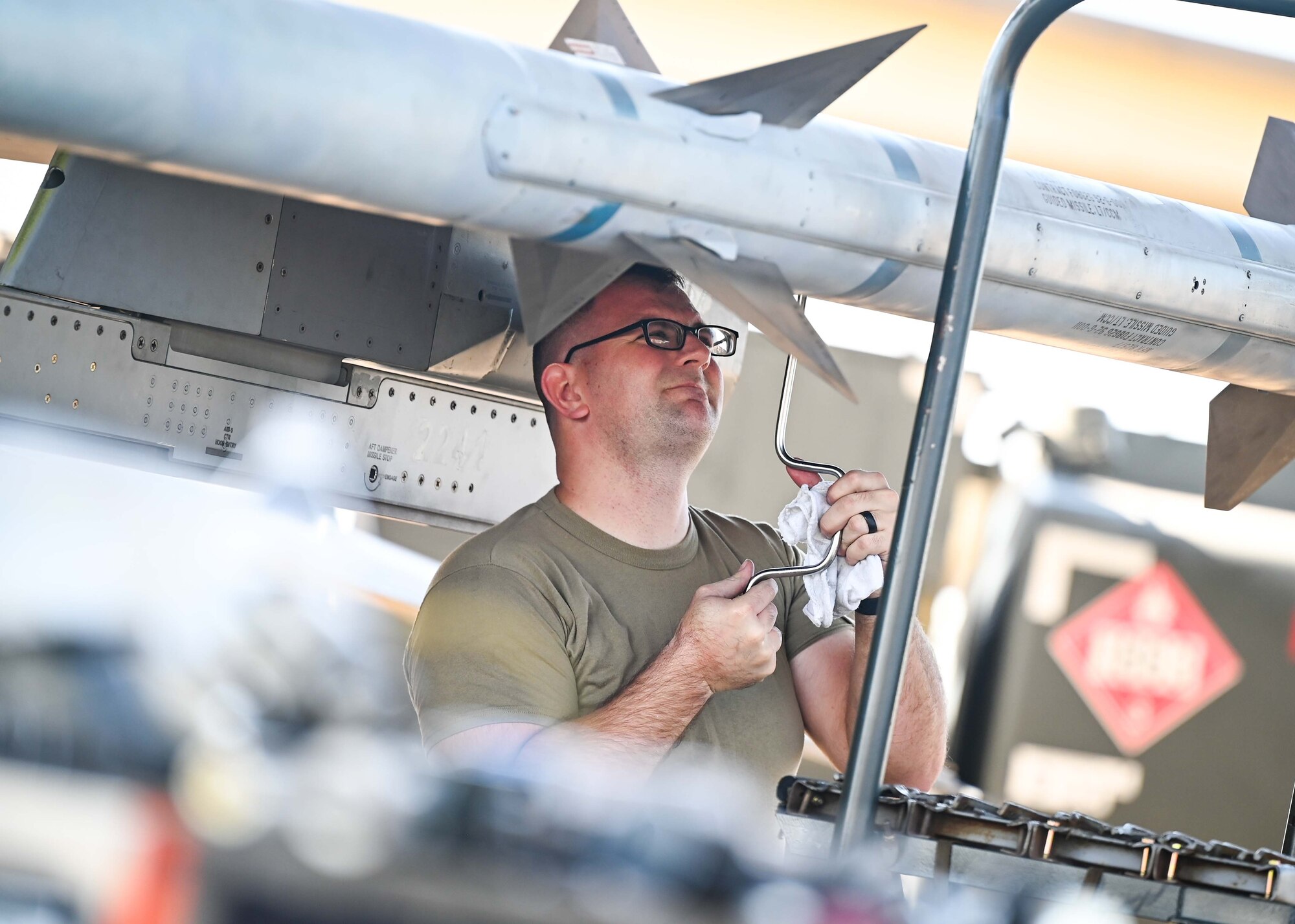 An Airman secures munitions onto an F-16.