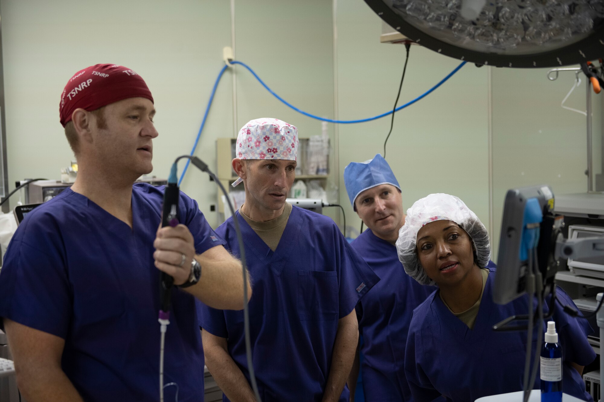 The base leadership watch a camera show through a manikin's esophagus