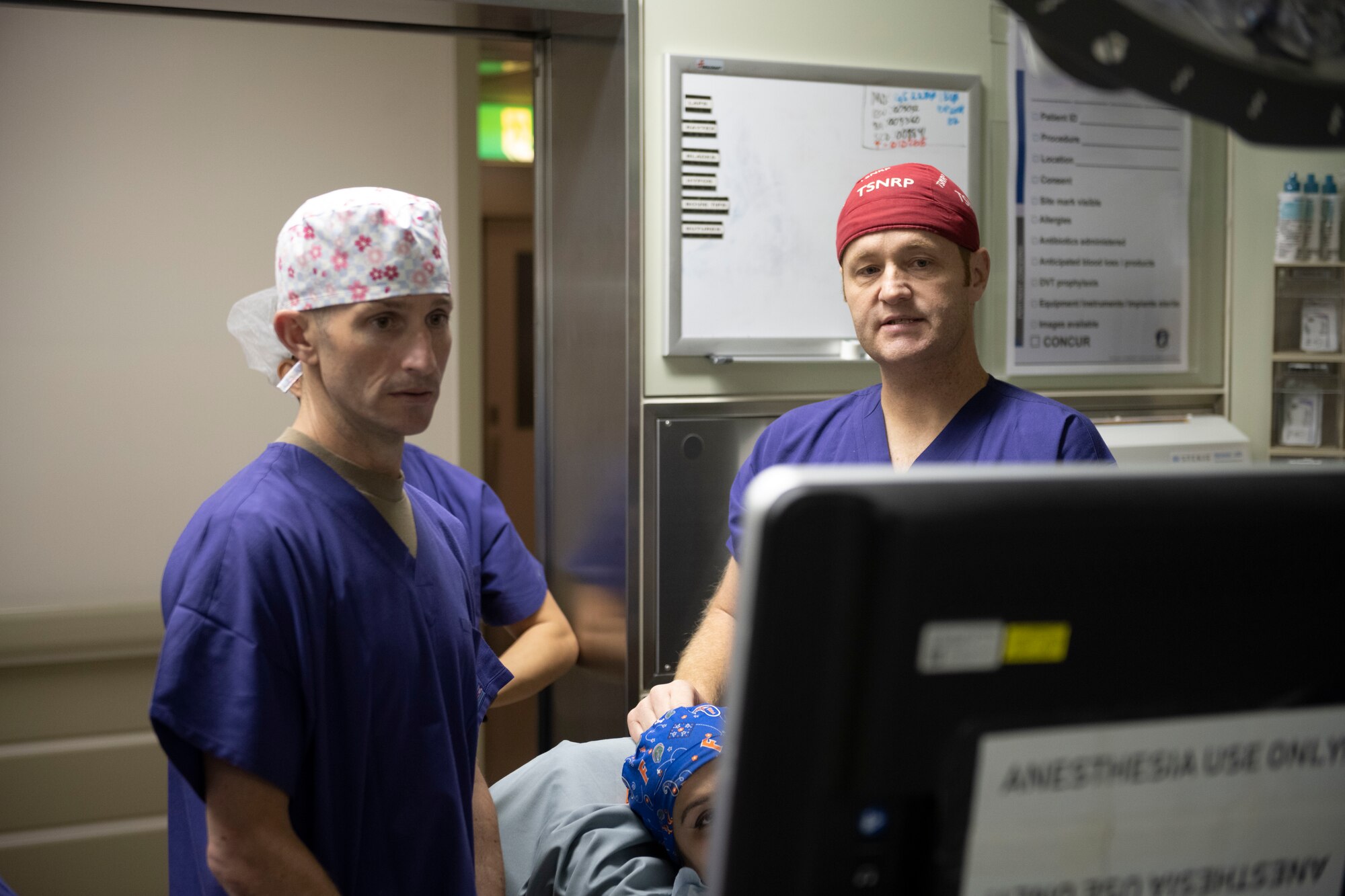 An officer shows the base commander where a nerve is on a human.