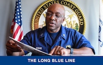 Chief Warrant Officer Kristopher McGhee reviews a scrapbook of milestones in his career in a conference room at Base Seattle, July 17, 2023. McGhee served in the health services field in the Coast Guard for over 30 years. U.S. Coast Guard photo by Petty Officer 3rd Class Annika Hirschler.