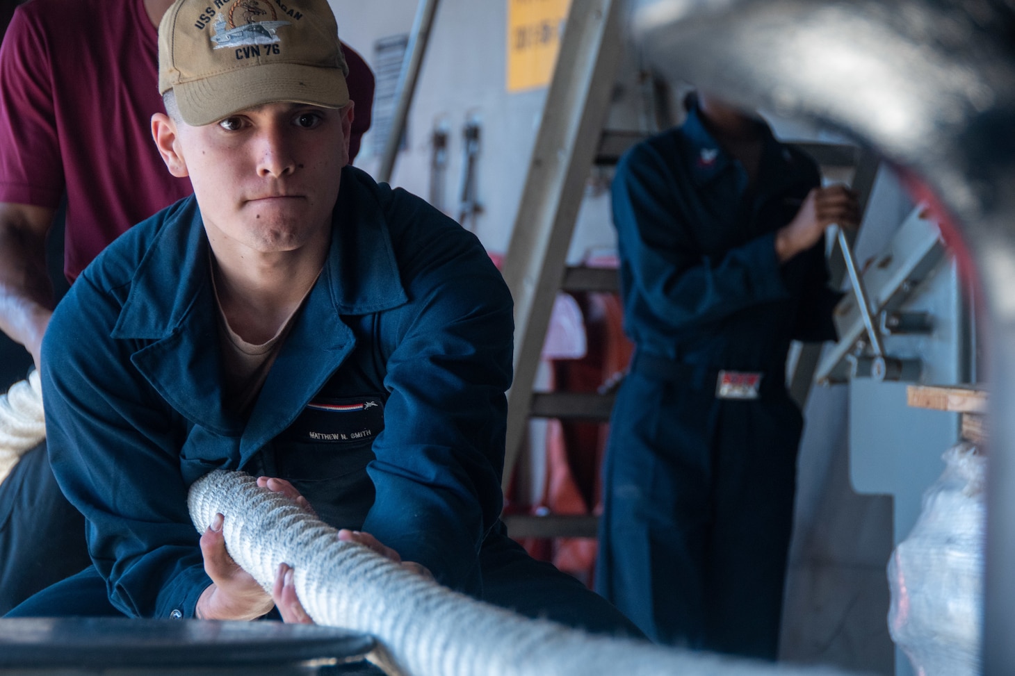 YOKOSUKA, Japan (Nov. 19, 2023) Seaman Matthew Smith, from Silverton, Oregon, heaves a mooring line on the fantail as the U.S. Navy’s only forward-deployed aircraft carrier, USS Ronald Reagan (CVN 76), returns to Commander, Fleet Activities Yokosuka, Japan, following a six-month deployment in the Indo-Pacific region, Nov. 19. During Ronald Reagan’s deployment, the ship conducted multinational exercises with the Japan Maritime Self-Defense Force (JMSDF), Royal Australian Navy, Indonesian Navy, and Republic of Korea Navy, a multi-large deck event with USS Carl Vinson (CVN 70), Carrier Strike Group 1, and JMSDF first-in-class helicopter destroyer, JS Hyuga (DDH 181), and visited Vietnam, Republic of Korea, and the Philippines. Ronald Reagan, the flagship of Carrier Strike Group 5, provides a combat-ready force that protects and defends the United States, and supports alliances, partnerships and collective maritime interests in the Indo-Pacific region. (U.S. Navy photo by Mass Communication Specialist Seaman Kaleb Birch)