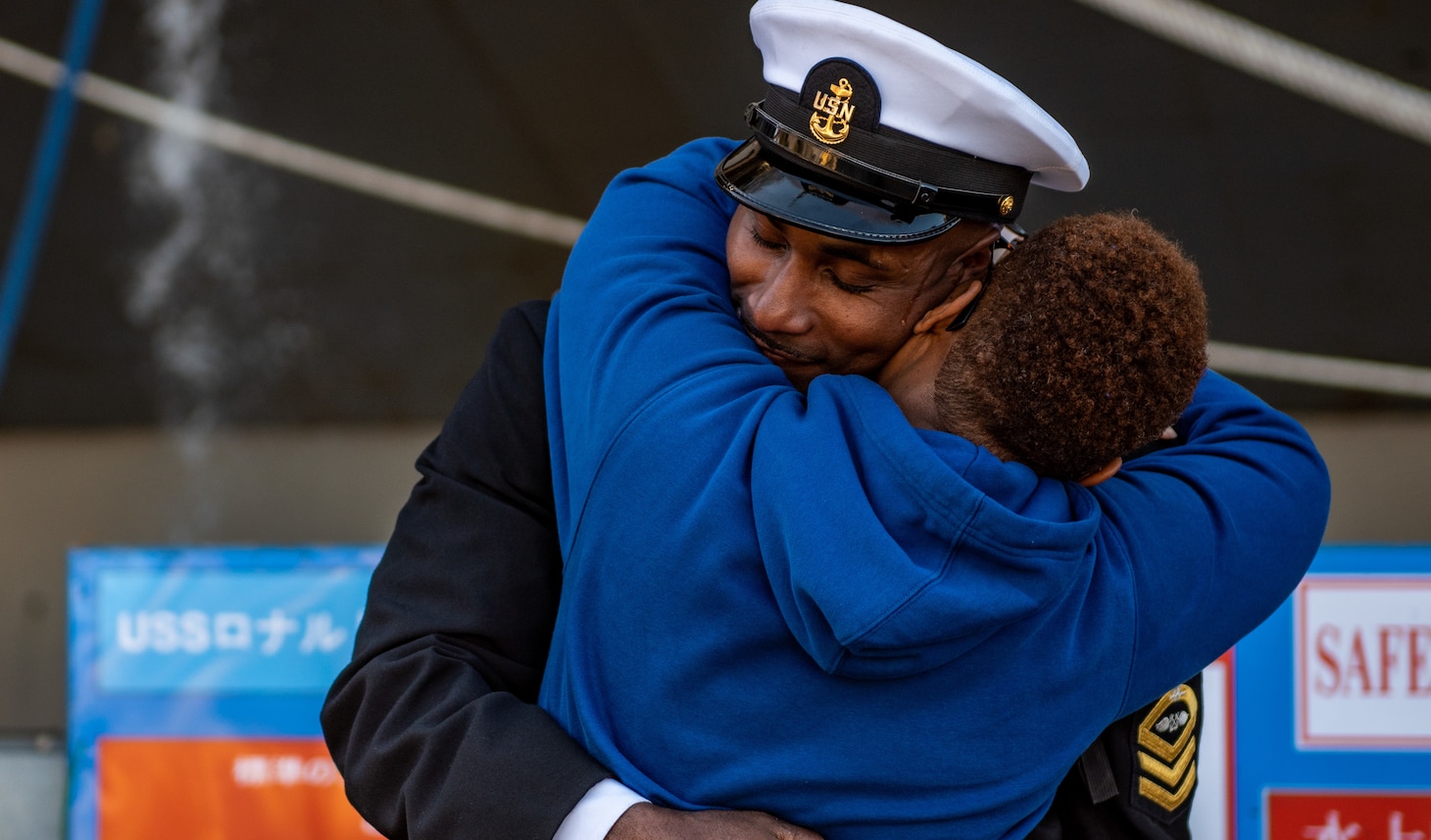 YOKOSUKA, Japan (Nov. 19, 2023) Chief Aviation Boatswain’s Mate (Aircraft Handling) Terry Keyes, from Bay Springs, Mississippi, greets a family member on the pier as the U.S. Navy’s only forward-deployed aircraft carrier, USS Ronald Reagan (CVN 76), returns to Commander, Fleet Activities Yokosuka, Japan, following a six-month deployment in the Indo-Pacific region, Nov. 19. During Ronald Reagan’s deployment, the ship conducted multinational exercises with the Japan Maritime Self-Defense Force (JMSDF), Royal Australian Navy, Indonesian Navy, and Republic of Korea Navy, a multi-large deck event with USS Carl Vinson (CVN 70), Carrier Strike Group 1, and JMSDF first-in-class helicopter destroyer JS Hyuga (DDH 181), and visited Vietnam, Republic of Korea, and the Philippines. Ronald Reagan, the flagship of Carrier Strike Group 5, provides a combat-ready force that protects and defends the United States, and supports alliances, partnerships and collective maritime interests in the Indo-Pacific region. (U.S. Navy photo by Mass Communication Specialist 2nd Class Caroline H. Lui)