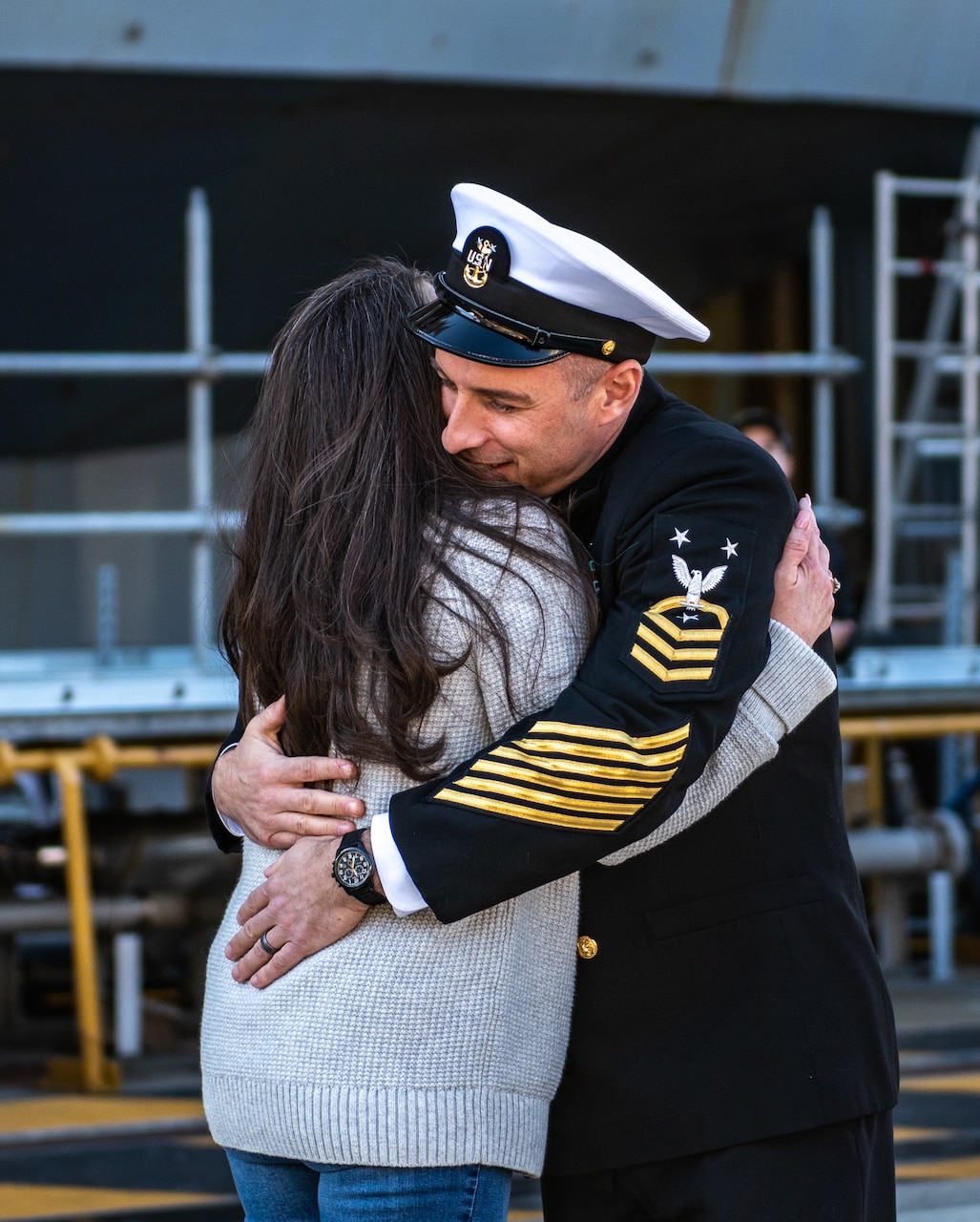 YOKOSUKA, Japan (Nov. 19, 2023) Command Master Chief Jeremy Douglas, command master chief of the U.S. Navy’s only forward-deployed aircraft carrier, USS Ronald Reagan (CVN 76), hugs his wife on the pier as the ship returns to Commander, Fleet Activities Yokosuka, Japan, following a six-month deployment in the Indo-Pacific region, Nov. 19. During Ronald Reagan’s deployment, the ship conducted multinational exercises with the Japan Maritime Self-Defense Force (JMSDF), Royal Australian Navy, Indonesian Navy, and Republic of Korea Navy, a multi-large deck event with USS Carl Vinson (CVN 70), Carrier Strike Group 1, and JMSDF first-in-class helicopter destroyer JS Hyuga (DDH 181), and visited Vietnam, Republic of Korea, and the Philippines. Ronald Reagan, the flagship of Carrier Strike Group 5, provides a combat-ready force that protects and defends the United States, and supports alliances, partnerships and collective maritime interests in the Indo-Pacific region. (U.S. Navy photo by Mass Communication Specialist 2nd Class Caroline H. Lui)