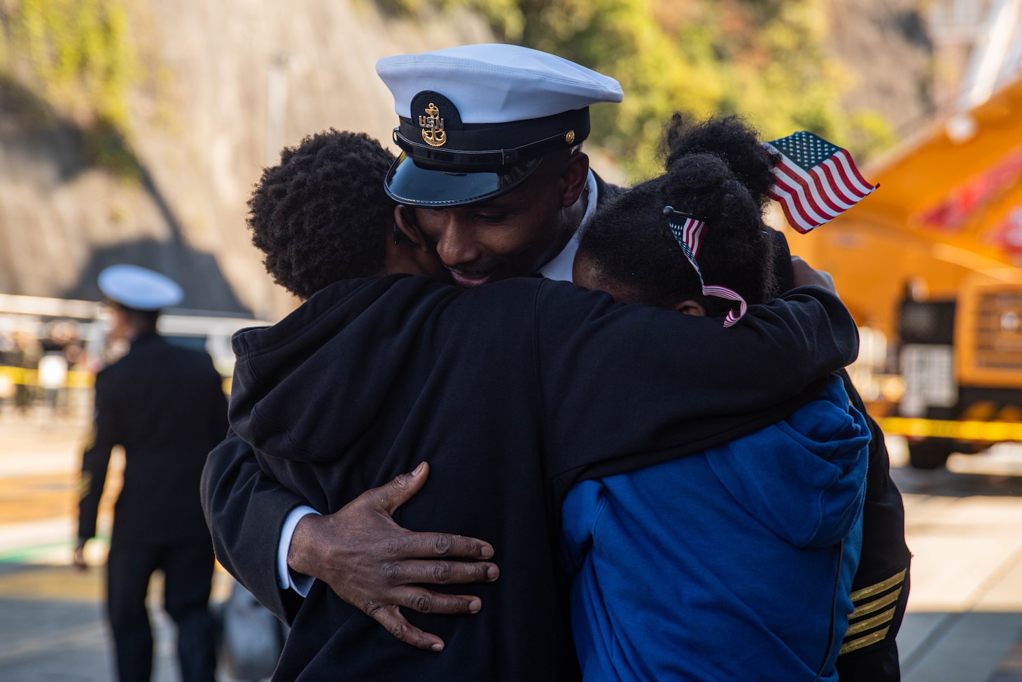 YOKOSUKA, Japan (Nov. 19, 2023) Chief Aviation Boatswain’s Mate (Aircraft Handling) Terry Keyes, from Bay Springs, Mississippi, embraces his children on the pier after the U.S. Navy’s only forward-deployed aircraft carrier, USS Ronald Reagan (CVN 76), returns to Commander, Fleet Activities Yokosuka, Japan, following a six-month deployment in the Indo-Pacific region, Nov. 19. During Ronald Reagan’s deployment, the ship conducted multinational exercises with the Japan Maritime Self-Defense Force (JMSDF), Royal Australian Navy, Indonesian Navy, and Republic of Korea Navy, a multi-large deck event with USS Carl Vinson (CVN 70), Carrier Strike Group 1, and JMSDF first-in-class helicopter destroyer JS Hyuga (DDH 181), and visited Vietnam, Republic of Korea, and the Philippines. Ronald Reagan, the flagship of Carrier Strike Group 5, provides a combat-ready force that protects and defends the United States, and supports alliances, partnerships and collective maritime interests in the Indo-Pacific region. (U.S. Navy photo by Mass Communication Specialist 3rd Class Jordan Brown)