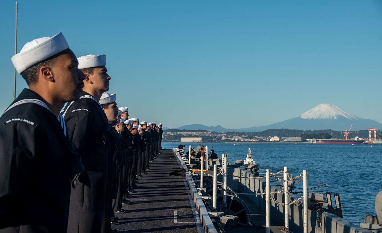 YOKOSUKA, Japan (Nov. 19, 2023) Sailors man the rails on the flight deck as the U.S. Navy’s only forward-deployed aircraft carrier, USS Ronald Reagan (CVN 76), returns to Commander, Fleet Activities Yokosuka, Japan, following a six-month deployment in the Indo-Pacific region, Nov. 19. During Ronald Reagan’s deployment, the ship conducted multinational exercises with the Japan Maritime Self-Defense Force (JMSDF), Royal Australian Navy, Indonesian Navy, and Republic of Korea Navy, a multi-large deck event with USS Carl Vinson (CVN 70), Carrier Strike Group 1, and JMSDF first-in-class helicopter destroyer, JS Hyuga (DDH 181), and visited Vietnam, Republic of Korea, and the Philippines. Ronald Reagan, the flagship of Carrier Strike Group 5, provides a combat-ready force that protects and defends the United States, and supports alliances, partnerships and collective maritime interests in the Indo-Pacific region. (U.S. Navy photo by Mass Communication Specialist 3rd Class Heather McGee)