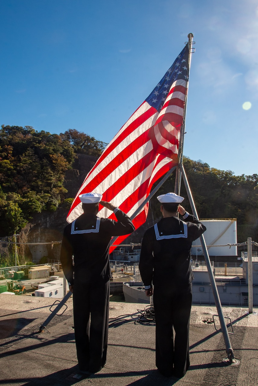 YOKOSUKA, Japan (Nov. 19, 2023) Aviation Boatswain’s Mate (Aircraft Handling) Airman Patrick Tizano, left, from Miami, and Aviation Boatswain’s Mate (Aircraft Handling) Jenri Gonzalez, from Hollywood, California, salute the ensign on the flight deck as the U.S. Navy’s only forward-deployed aircraft carrier, USS Ronald Reagan (CVN 76), returns to Commander, Fleet Activities Yokosuka, Japan, following a six-month deployment in the Indo-Pacific region, Nov. 19. During Ronald Reagan’s deployment, the ship conducted multinational exercises with the Japan Maritime Self-Defense Force (JMSDF), Royal Australian Navy, Indonesian Navy, and Republic of Korea Navy, a multi-large deck event with USS Carl Vinson (CVN 70), Carrier Strike Group 1, and JMSDF first-in-class helicopter destroyer, JS Hyuga (DDH 181), and visited Vietnam, Republic of Korea, and the Philippines. Ronald Reagan, the flagship of Carrier Strike Group 5, provides a combat-ready force that protects and defends the United States, and supports alliances, partnerships and collective maritime interests in the Indo-Pacific region. (U.S. Navy photo by Mass Communication Specialist 3rd Class Heather McGee)