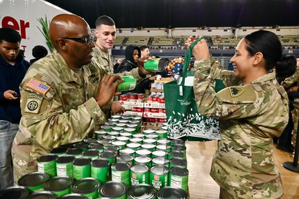 Harlem Globetrotters "Too Tall” Winston and "Wham” Middleton thank District of Columbia National Guard members, while also participating in a holiday meal distribution during a Operation Homefront ‘Holiday Meals for Military’ event at the D.C. Armory on Nov. 17, 2023. Operation Homefront provides programs designed to build strong, stable, and secure military families. (U.S. Air National Guard photo by MSgt Arthur M. Wright)