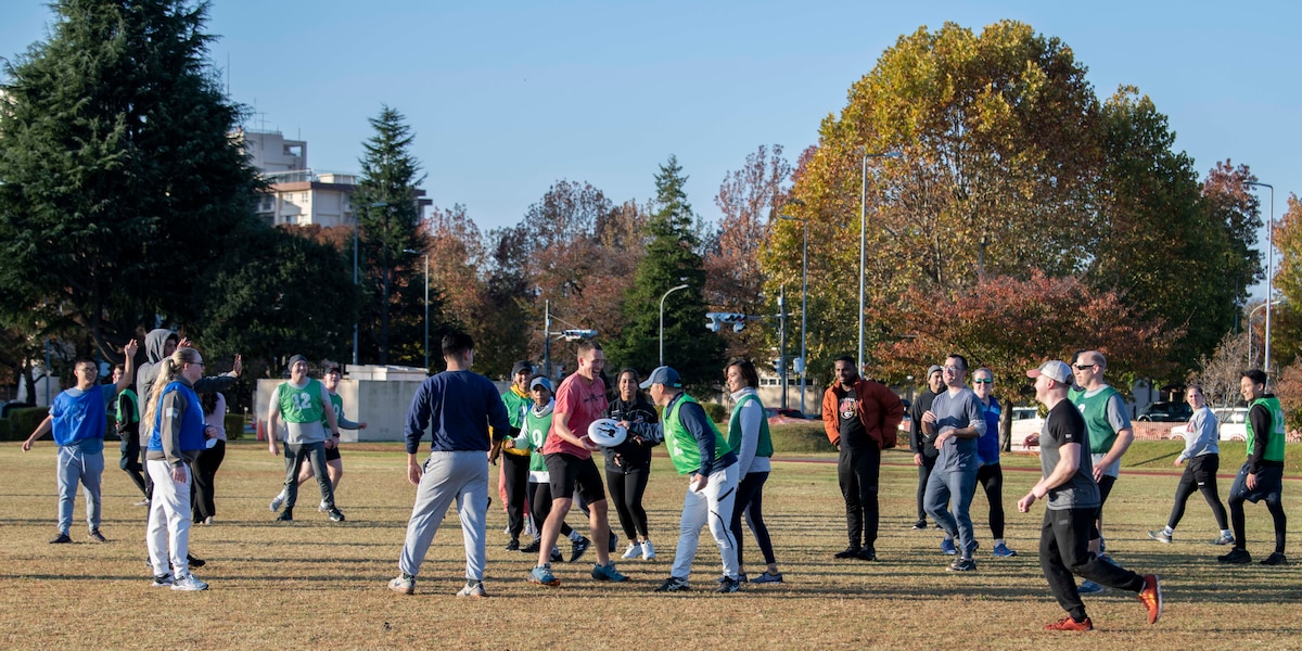 A group of military members play ultimate frisbee.