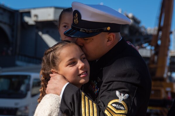 YOKOSUKA, Japan (Nov. 19, 2023) Chief Aviation Boatswain’s Mate (Launch/Recovery Equipment) Steven Castro, from El Centro, California, kisses his daughter on the pier as the U.S. Navy’s only forward-deployed aircraft carrier, USS Ronald Reagan (CVN 76), returns to Commander, Fleet Activities Yokosuka, Japan, following a six-month deployment in the Indo-Pacific region, Nov. 19. During Ronald Reagan’s deployment, the ship conducted multinational exercises with the Japan Maritime Self-Defense Force (JMSDF), Royal Australian Navy, Indonesian Navy, and Republic of Korea Navy, a multi-large deck event with USS Carl Vinson (CVN 70), Carrier Strike Group 1, and JMSDF first-in-class helicopter destroyer JS Hyuga (DDH 181), and visited Vietnam, Republic of Korea, and the Philippines. Ronald Reagan, the flagship of Carrier Strike Group 5, provides a combat-ready force that protects and defends the United States, and supports alliances, partnerships and collective maritime interests in the Indo-Pacific region. (U.S. Navy photo by Mass Communication Specialist 3rd Class Jordan Brown)