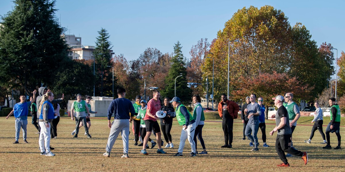 A group of military members play ultimate frisbee.