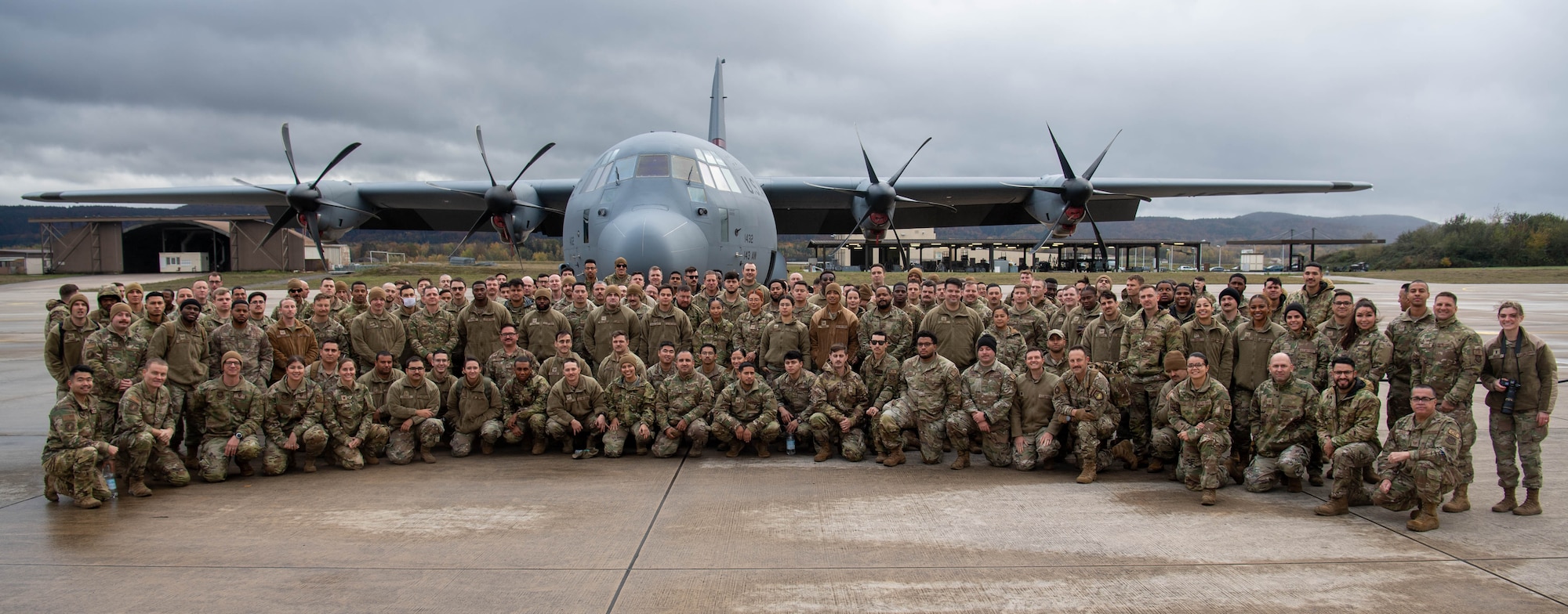 U.S. Air Force Airmen assigned to the 37th Airlift Squadron, as well as deployed Airmen assigned to the 621st Contingency Response Wing, Travis Air Force Base, California, and Quonset Point Air National Guard Station, Rhode Island, pose for a photo in front of a C-130J Super Hercules aircraft following floor-loading training at Ramstein Air Base, Germany, Nov. 9, 2023. The 37th AS held this training event to rehearse floor-loading procedures used primarily in contingency operations and humanitarian aid missions, during which the maximum number of passengers are loaded onto an aircraft without the standard use of seatbelts or stanchions. (U.S. Air Force photo by Senior Airman Jared Lovett)