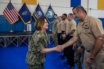 U.S. NAVAL BASE GUAM (Nov. 20, 2023) – Chief of Naval Operations Adm. Lisa Franchetti reenlists Sailors during an all-hands call while visiting Naval Base Guam, Nov. 20. Franchetti and and Master Chief Petty Officer of the Navy James Honea  visited Naval Base Guam to engage with Sailors and Navy leadership to highlight Franchetti's priority of strengthening the Navy team. (U.S. Navy photo by Chief Mass Communication Specialist Amanda R. Gray)