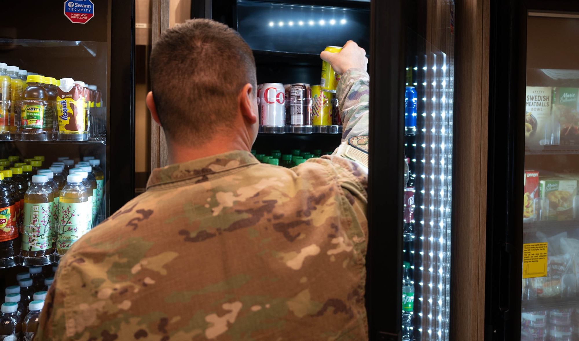 Tech. Sgt. Mark Malley, 5th Civil Engineering Squadron dorm management, grabs a beverage inside the newly opened Myers Market at Minot Air Force Base, North Dakota, Nov. 15, 2023. Myers Market is located inside the Vosler Hall dormitory and provides beverages, snacks, candy and frozen food available for Airmen to purchase. (U.S. Air Force photo by Airman 1st Class Luis Gomez)