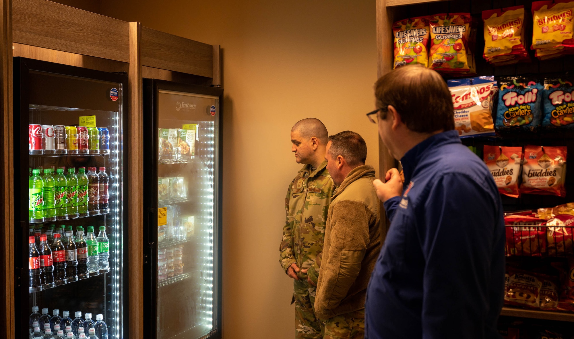 Members of team Minot looking at the frozen food section of the newly opened Myers Market at Minot Air Force Base, North Dakota, Nov. 15, 2023. Myers Market is a corner store located inside the Vosler Hall dormitory providing convenient food and beverage options to Airmen. (U.S. Air Force photo by Airman 1st Class Luis Gomez)