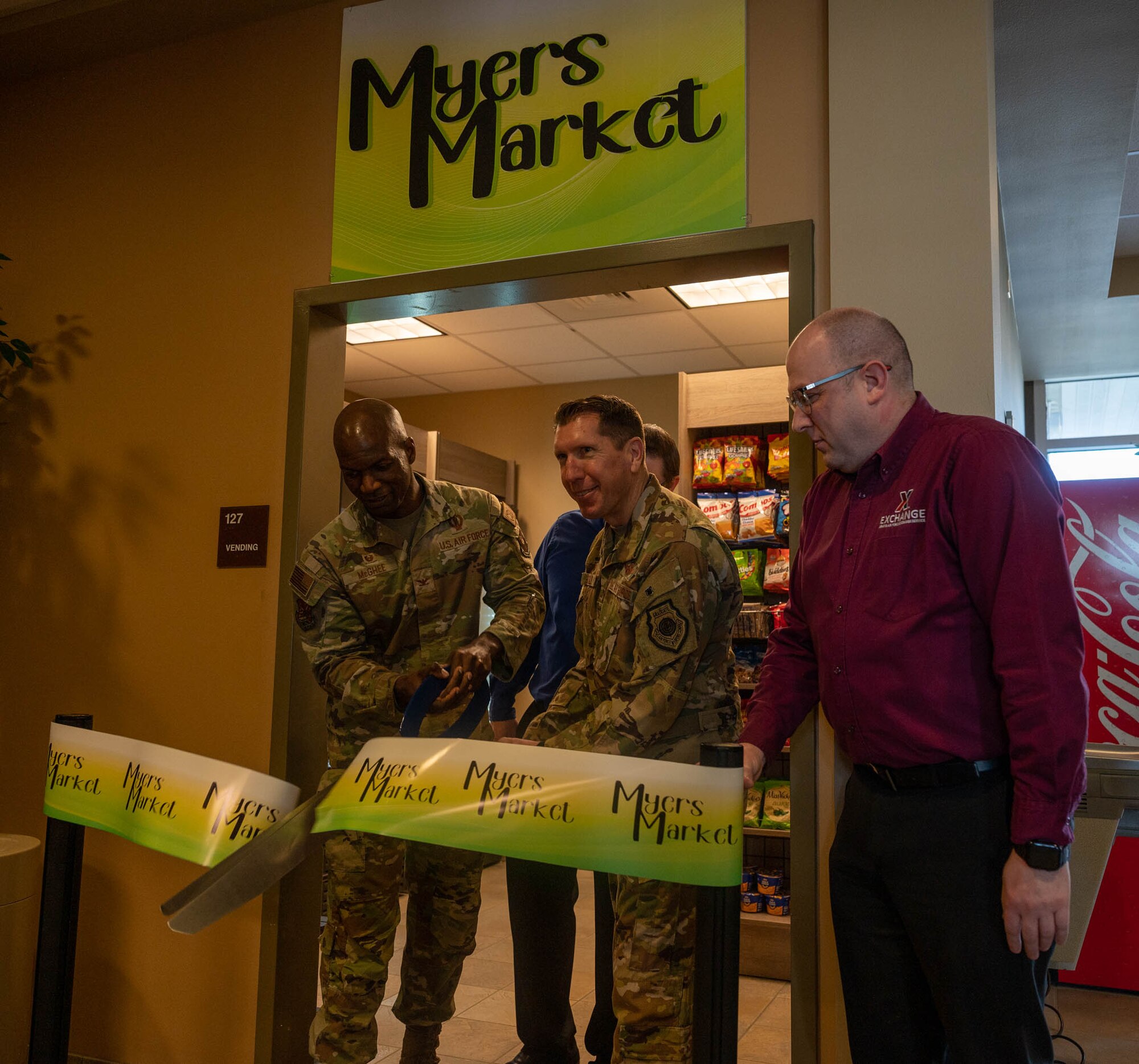 U.S. Air Force Col. Daniel Hoadley, 5th Bomb Wing commander (right), and U.S. Air Force Col. Kenneth Mcghee, 91st Missile Wing commander cut the ribbon at the grand opening of Myers Market at Minot Air Force Base, North Dakota, Nov. 15, 2023. Myers Market gives Airmen living in the dorms access to more food and beverage options. It also aids Airmen during winter months when traveling elsewhere for food could be inconvenient. (U.S. Air Force photo by Airman 1st Class Luis Gomez)