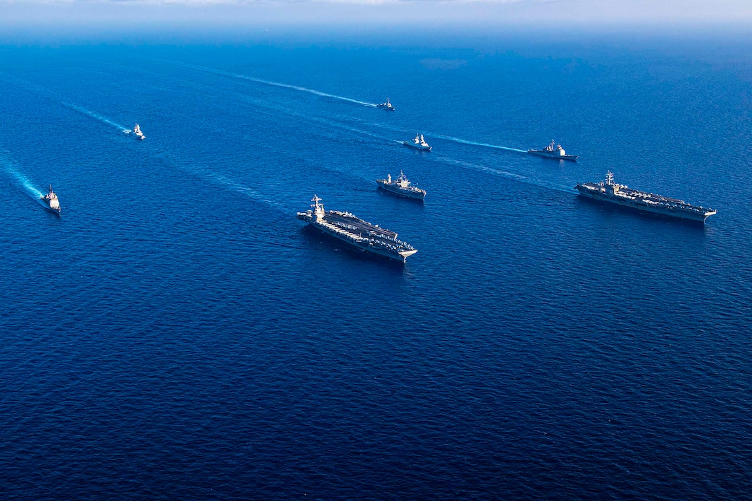 Ships sail in formation in the Mediterranean Sea.