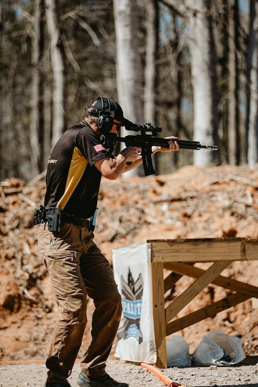 Man in Army Polo shooting rifle.