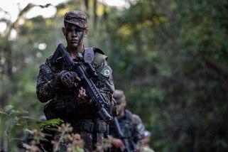 A Brazilian Soldier walks down a trail during the final movement of Exercise Southern Vanguard 24.