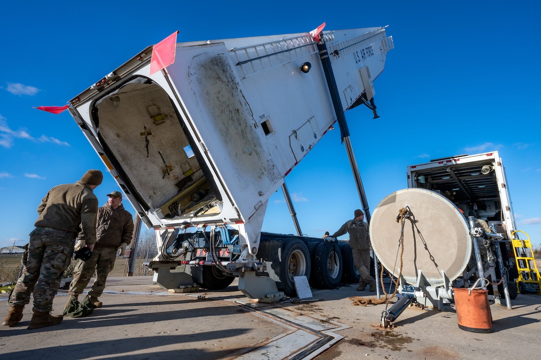 Airmen operate a transporter erector which stores large missiles.
